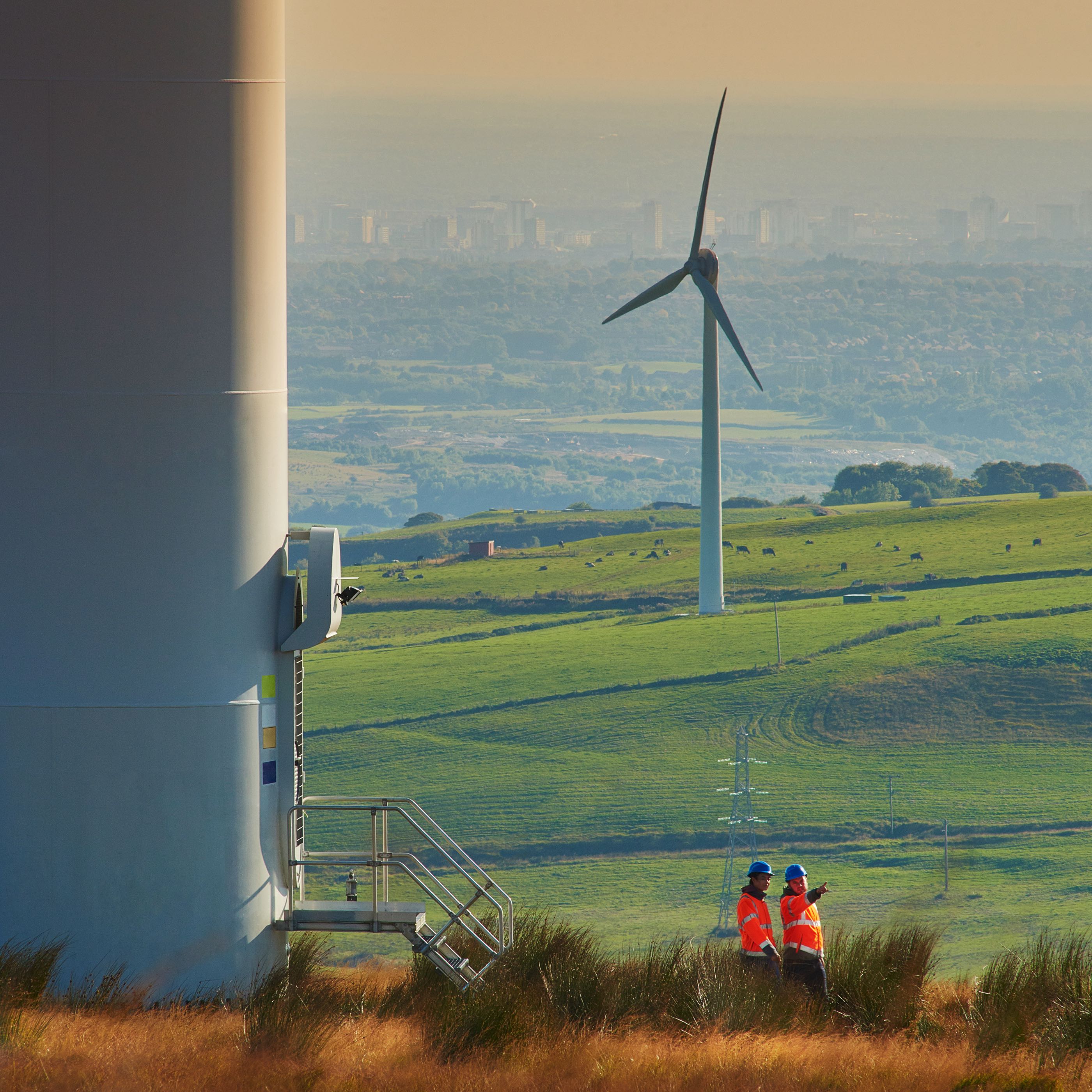 Wind turbine with cityscape in background