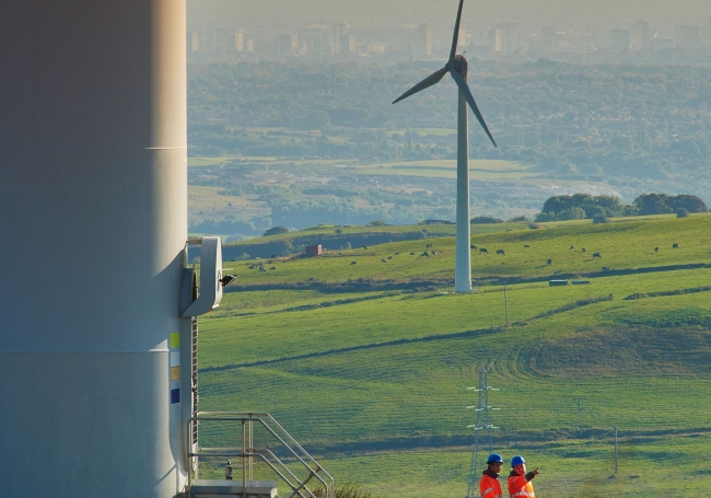 Wind turbine with cityscape in background